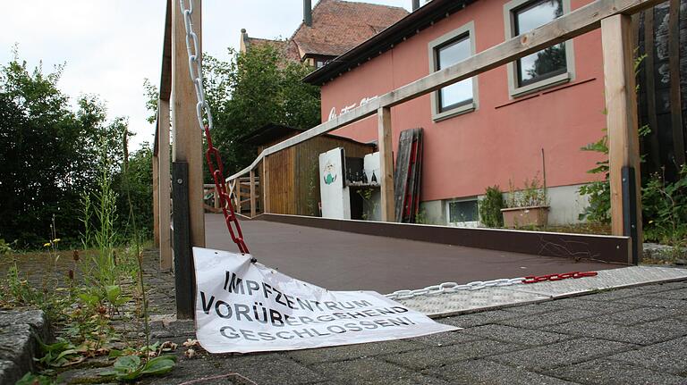 Ein am Boden liegender Zettel weist darauf hin, dass die Impfstelle in der Gerolzhöfer Stadthalle nicht mehr in Betrieb ist.