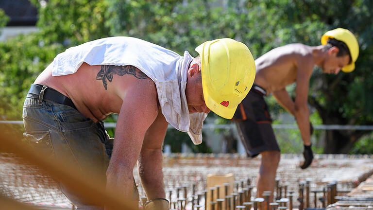 Schatten Fehlanzeige: Wie arbeitet es sich bei der Hitze?       -  Mitarbeiter der Baufirma Liebstückel bei 34 Grad auf dem Dach des Rohbaus auf der Baustelle am Franziskaner-Minoritenkloster in Würzburg.