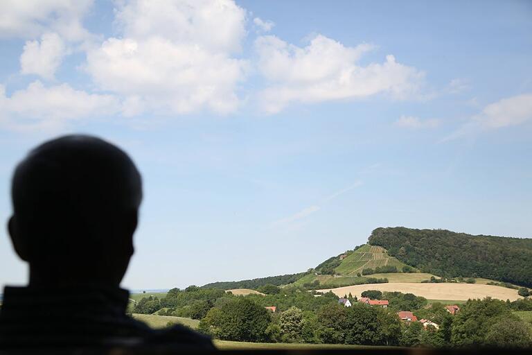 Der Mensch und die Natur: Am Franziskusweg gibt es immer atemberaubende Ausblicke über Wiesen und Felder hinunter zum Dorf mit den dahinterliegenden Weinbergen an der Stollburg.