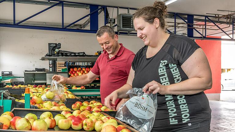 Beim Verpacken mit Obstbaumeister Rainer Böhm gilt für Redaktionsvolontärin Anna Kirschner: vorsichtig mit dem Produkt umgehen und die Qualität kontrollieren.