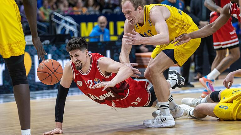 Bauchlandung für die Würzburg Baskets: Nicolas Carvacho (in rot) hechtet vergeblich dem Ball hinterher.Luke Sikma (rechts) beobachtet und Christ Koumadje (links) schnappt sich den Ball. Bauchlandung für die Würzburg Baskets: Nicolas Carvacho (in rot) hechtet vergeblich dem Ball hinterher.Luke Sikma (rechts) beobachtet und Christ Koumadje (links) schnappt sich den Ball. 