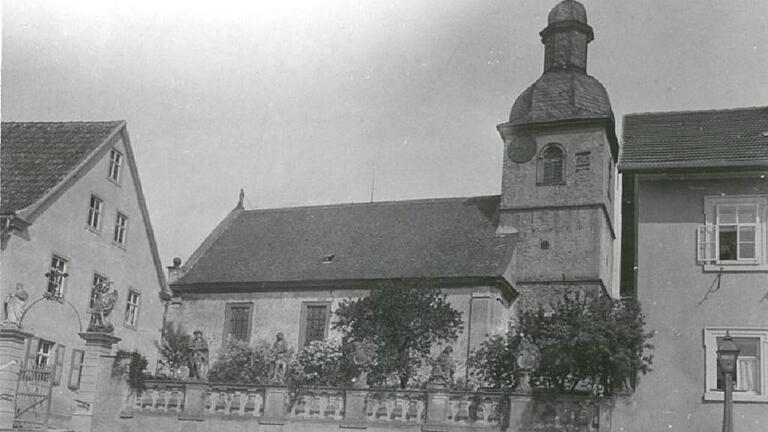 Die historische Aufnahme aus Rannungen zeigt die alte Mauer-Umfriedung, hinter der einst der Kirchvorplatz verborgen lag. Links das frühere Rathaus, das abgebrochen wurde. Die Aufnahme stammt, nach Einschätzung der Verwaltung, aus den 1950er oder 1960er Jahren.