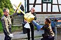 Pfarrerin Christel Kupfer steckt den Zylinder mit den alten und neuen Chronikdokumenten in den Turmknopf, der nun wieder die Dorfkirche von Weimarschmieden krönt. Ein Arbeiter der Firma Dietz aus Fladungen sowie der Leiter des Gesamtsanierungsprojekts, Christoph Bauer (Mitte), halten die nicht ganz leichte Turmbekrönung.