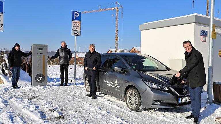 An der neuen Ladestation in der Haupterschließungstraße 'An den Fichtenäckern' des Veitshöchheimer Wohngebietes Sandäcker (von links): der gemeindliche Klimaschutzmanager Jan Speth,  Geschäftsführer Marek Zelezny und kaufmännischer Leiter Stefan Schinagl ('Energie') sowie Bürgermeister Jürgen Götz.