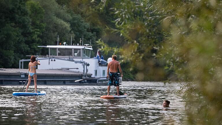 Bei gutem Wetter sind neben Schiffen viele Menschen als Schwimmer oder Stand-up-Paddler im Main unterwegs, wie hier in der Sanderau in Würzburg.