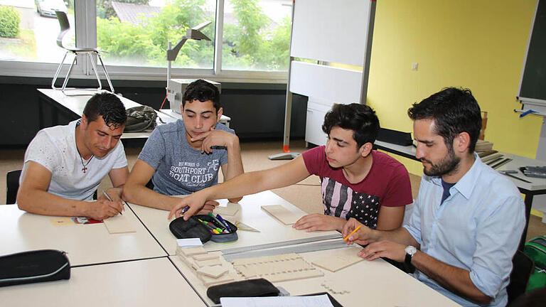 Quaseem Ramdad, Ahmad Sosan, Mohammed Allaham und Lehrer Philipp Oberhagemann (von links) beteiten die Kästchen für Karteikarten zum Vokabellernen vor.  Foto: Thomas Malz       -  Quaseem Ramdad, Ahmad Sosan, Mohammed Allaham und Lehrer Philipp Oberhagemann (von links) beteiten die Kästchen für Karteikarten zum Vokabellernen vor.  Foto: Thomas Malz