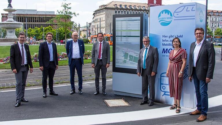 Smartes Display am Hauptbahnhof (von links): Oberbürgermeister Christian Schuchardt, Klimabürgermeister Martin Heilig, WVV-Vorstand Robert Konrad, Baureferent Benjamin Schneider, WVV-Geschäftsführer Thomas Schäfer, Annette Messerer (Fachabteilung Tiefbau) und Volker Grießmann (Siemens Mobility GmbH) am neuen Mobilitätsmonitor am Würzburger Hauptbahnhof.