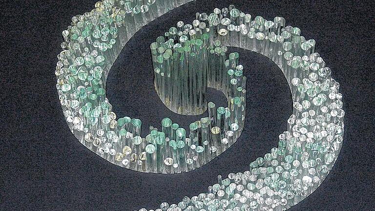 Zerbrechliche Spirale des Lebens       -  (hon)   Zum deutschen &bdquo;5. Immenhäuser Glaspreis&ldquo; im Glasmuseum in Immenhausen bei Kassel wurden die Estenfelder Künstler Hermann und Marga Heinickel  eingeladen. Maximal zwei nach 2009 entstandene Werke konnten hierzu eingereicht werden. Das Ehepaar, welches sich seit 1998 als &bdquo;Quereinsteiger&ldquo; mit der Verschmelztechnik, dem sogenannten Fusing befasst, wurde wiederum genommen. Es ist nach 2006 und 2009 das dritte Mal. Mit je zwei Werken sind sie nun in der Ausstellung vertreten,  die am 29. September mit der Preisverleihung endet. Insgesamt nehmen 83 Glaskünstler aus ganz Deutschland teil. Aus dem gesamten fränkischen Raum kommen vier und aus Unterfranken nur Hermann und Marga Heinickel. Marga Heinickel zeigt die &bdquo;Spirale des Lebens&ldquo; (im Bild), wozu sie nahezu 800 Vollglasstäbe unterschiedlicher Stärke und Höhe verarbeitete. Ihr zweites Werk heißt: &bdquo;11.3.11 &ndash; Erdbeben in Japan&ldquo;. &bdquo;Farbenspiel&ldquo; und &bdquo;Tsunami&ldquo; sind die Titel der beiden Objekte von Hermann Heinickel. Und eine weitere erfreuliche Nachricht erreichte das Ehepaar dieser Tage:  Sie wurden wie schon 2010 erneut ausgewählt, jeweils mit ihren beiden Glasobjekten auch an der Internationalen  Glaskunstausstellung im Herbst in Zwiesel teilzunehmen.