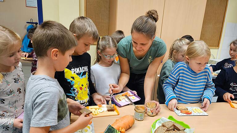 Svenja Arbes, Projektmanagerin der Öko-Modellregion Rhön-Grabfeld, mit teilnehmenden Schülerinnen und Schülern am Frühstücksbuffet.