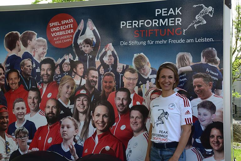 Magdalena Neuner vor dem Plakat der Peak Performer Stiftung. Magdalena Neuner vor dem Plakat der Peak Performer Stiftung.