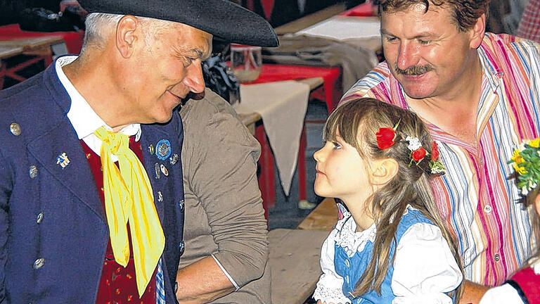 Schau mir in die Augen, Kleines: Alt und Jung trafen sich &ndash; in traditioneller Tracht &ndash; am Sonntag beim 7. Unterfränkischen Volksmusikfest in Castell. Auch wenn es zum Auftakt immer wieder in Strömen regnete und sich die Plätze vor dem Rathaus, dem Tränkbrunnen und im Schlosspark nur langsam mit Besuchern füllte, wurde das Fest ein Erfolg. Den mit dem Sonnenschein am Nachmittag, kamen auch scharenweise die Gäste.