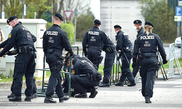 Polizisten bauen am Mittag des 1. Mai die Absperrungen rund um den Volksfestplatz wieder ab, nachdem keine Kundgebungsteilnehmer mehr erwartet wurden.