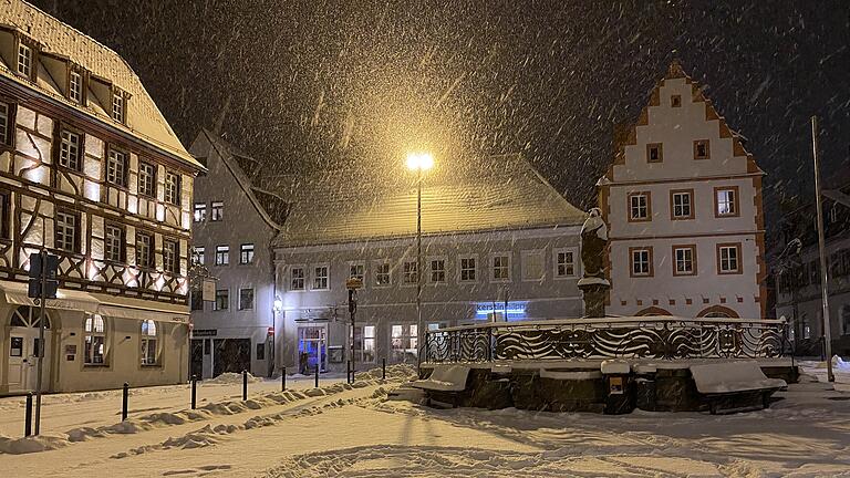 Die Volkacher Altstadt war am Montagabend vom Schnee bedeckt und die Flocken fielen weiter. Das Bild zeigt den Blick vom Rathaus auf den eingeschneiten Marktplatz und den Marktbrunnen.