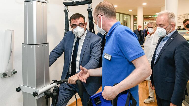 Gesundheitsminister am Trainingsgerät: Physiotherapeut Helmut Werner erklärt Klaus Holetschek (links), wie betagte Patientinnen und Patienten in der Geriatrischen Reha-Klinik der AWO in Würzburg wieder fit gemacht werden für den Alltag. Rechts AWO-Bezirksgeschäftsführer Martin Ulses. Gesundheitsminister am Trainingsgerät: Physiotherapeut Helmut Werner erklärt Klaus Holetschek (links), wie betagte Patientinnen und Patienten in der Geriatrischen Reha-Klinik der AWO in Würzburg wieder fit gemacht werden für den Alltag. Rechts AWO-Bezirksgeschäftsführer Martin Ulses.
