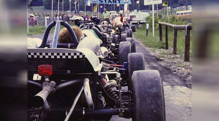 Aufgereiht vor dem Start: Rennwagen beim Schwanbergrennen 1976. Die erste Rechtskurve nach dem Start heißt Betty-Paulus-Gedächtniskurve, benannt nach einer Frau, die den AMC bei allen Rennen nach Kräften unterstützte.