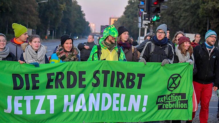 Aktivisten von 'Extinction Rebellion' mit einem Banner bei den Protesten an der Berliner Siegessäule.