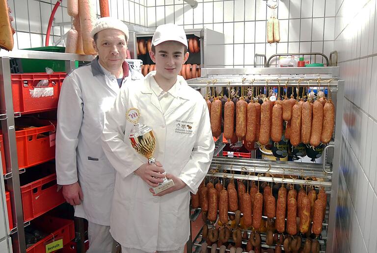 Paul Olbrich mit seinem Siegerpokal im Kühlhaus der Hof-Metzgerei in Unterpleichfeld. Sein Chef Metzgermeister Johannes Lukas (links) ist stolz auf seinen Auszubildenden.