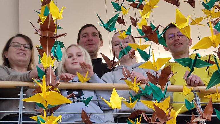 1200 Kraniche aus Papier symbolisieren in der Giebelstadter Bücherei die 1200-jährige Geschichte des Orts und die Hoffnung auf Frieden, von links Büchereileiterin Monika Schmitt und stellvertretend für alle, die Kraniche gefaltet haben, Lina Hilpert, Manfred Landauer, Jule Hilpert und Initiator Thomas Schenkel.