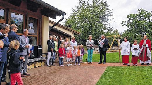Feierstunde: Bürgermeister Konrad Schlier beglückwünscht Kindergartenleiterin Karin Rottmann bei der Segnung des neuen Außengeländes des Dipbacher Kindergartens; rechts Pfarrvikar Duc Ninh Nguyen.
