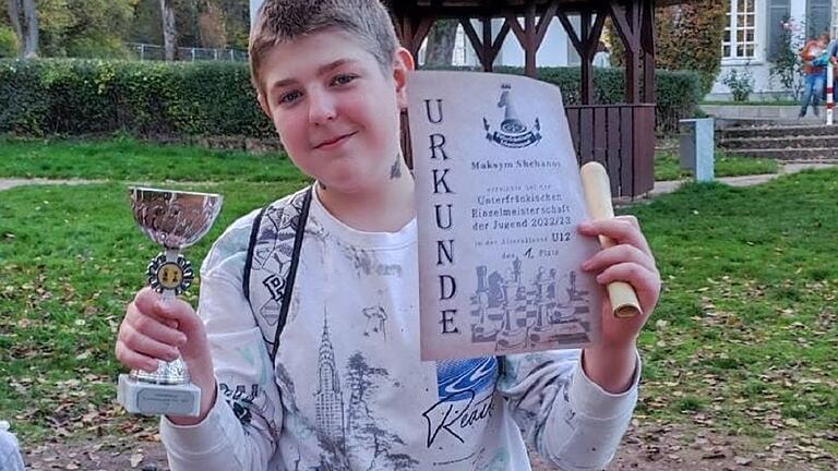Stolz präsentiert Maksym Shebanova den unterfränkischen Pokal und die Urkunde, die das elfjährige Randersackerer Talent als Meister im Schach ausweist. Das Besondere: Maksym kam erst im April aus dem Kriegsgebiet der Ukraine an den Main. Stolz präsentiert Maksym Shebanova den unterfränkischen Pokal und die Urkunde, die das elfjährige Randersackerer Talent als Meister im Schach ausweist. Das Besondere: Maksym kam erst im April aus dem Kriegsgebiet der Ukraine an den Main.
