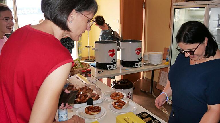 Pfarrgemeinderatsvorsitzende Carolin Saccavino (rechts) beim Weißwurstfrühstücksverkauf im Hausener Dorf-Treff.