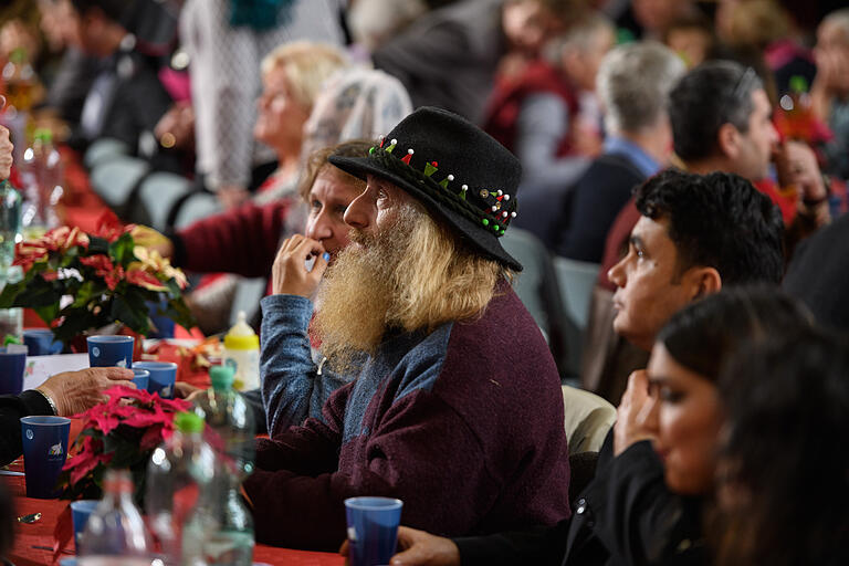 Für alle gibt es nach dem Singen von Weihnachtsliedern eine warme Suppe, die Auswahl zwischen zwei Hauptgerichten und eine Nachspeise. Dies alles wurde von Mitgliedern von Sant‘Egidio und Sponsoren in tagelanger Arbeit vorbereitet und nun von den Helfern am Tisch serviert.