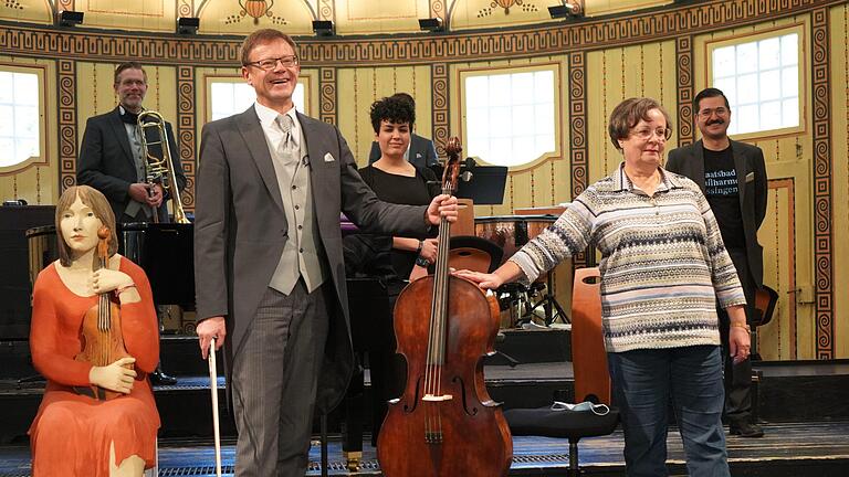 Orchestermitglied Ilia Zhukovski (links) nimmt von Karoline Ziegert (rechts) das restaurierte Cello entgegen. Daniel Scheublein       -  Orchestermitglied Ilia Zhukovski (links) nimmt von Karoline Ziegert (rechts) das restaurierte Cello entgegen. Daniel Scheublein