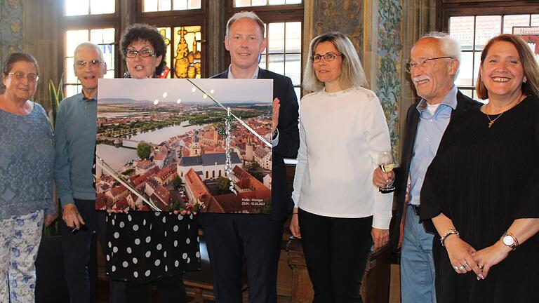 Ein großformatiges Luftbild von der Kitzinger Altstadt überreichte OB Stefan Güntner den Gästen aus Prades. Das Bild zeigt die Referentin für die Partnerschaft Jocelyne Nicoly, Emile Claverie, Präsident de Jumelage Prades, Geraldine Bouvier, stellvertretende Bürgermeisterin von Prades, OB Stefan Güntner, Nathalie Cornet (Stadträtin in Prades), Alt-OB Bernd Moser, Vorsitzender Freundeskreis der Partnerstädte und Glady Da-Silva, Stadträtin in Prades.