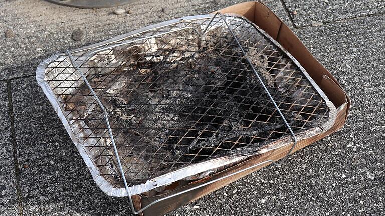 Nur einmal genutzt: ein Einweggrill, der samt Verpackung am Kitzinger Mainufer zurückgelassen wurde.