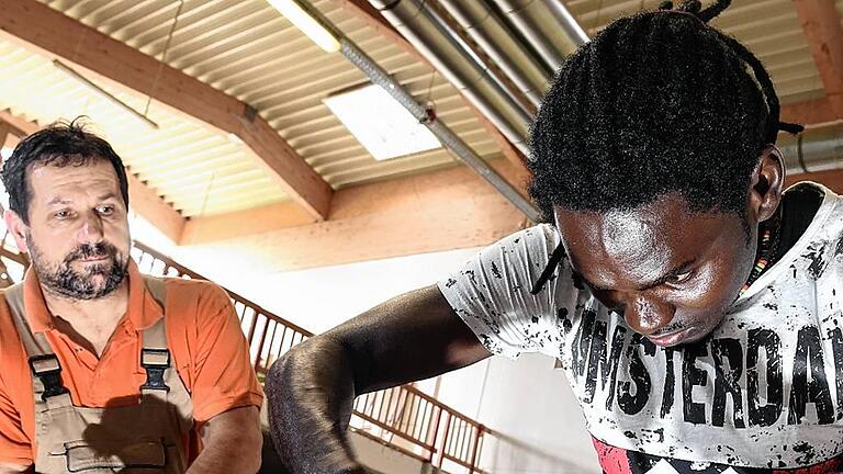 Flüchtling macht Schreiner-Ausbildung       -  Asylbewerber Omar Ceesay (rechts) arbeitet in der Schreinerei Holitsch in Tettnang-Hiltensweiler (Baden-Württemberg) an einer Tür, Schreiner Karl-Heinz Kübler schaut zu.