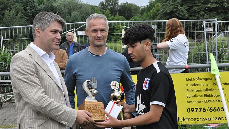 Mellrichstadts Bürgermeister Michael Kraus (links) und Ehrengast Christian Wück (Mitte) überreichten den Silberdistel-Cup an Armin Rasuli von der SG Barockstadt Fulda-Lehnerz.