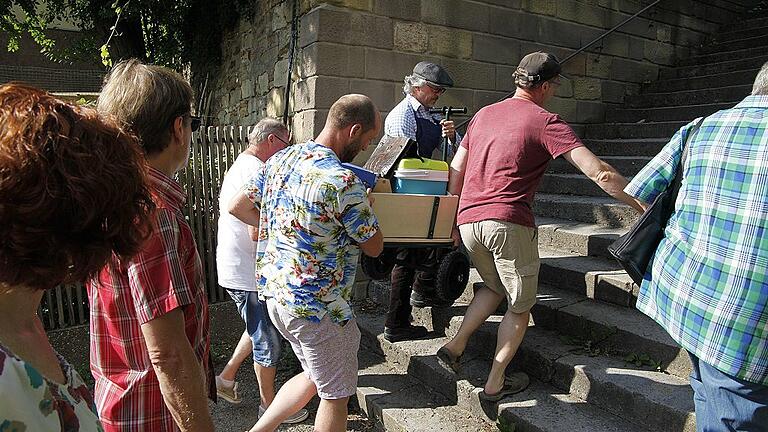 Ohne Wägelchen geht nichts: Mit tatkräftiger Hilfe bekommt der Biermichel sein wichtigstes Utensil, den Anhänger mit dem Bier und den Gläsern für die kleinen Verköstigungen während der Stadtführung, die Treppen zum Unteren Wall hinauf.