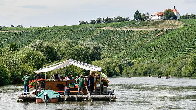 Vorbei an den Weinbergen an der Mainschleife bei Volkach. Die Fahrt auf dem 20m langen und 7,5m btreiten Floß dauert 3,5 Stunden und führt von Astheim bis Sommerach.