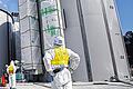 Fukushima: Ein Arbeiter im Schutzanzug schaut den Schweißarbeiten an einem Behälter für radioaktives Wasser zu.