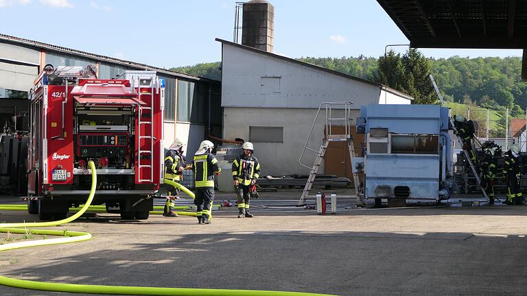 Die Feuerwehr verhinderte ein Übergreifen der Flammen auf ein großes Holzdach (rechts) in unmittelbarer Nähe der brennenden Maschine.