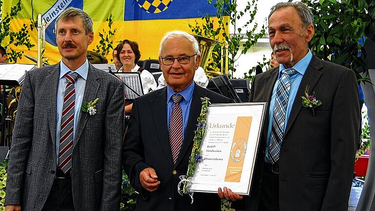 Gerhard Hartmann, Leiter des Vermessungsamtes (links), und Feldgeschworenen-Kreisobmann Wendelin Jooß (rechts) ernannten Landrat Rudolf Handwerker zum Ehrensiebener.