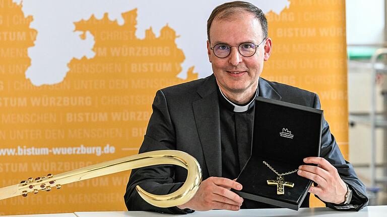 Der ernannte Würzburger Weihbischof Paul Reder zeigt&nbsp; bei einer Pressekonferenz seine Insignien: den Bischofsstab (links) sowie das Bischofskreuz. Beides hat er sich aus dem Fundus der Diözese ausgesucht.