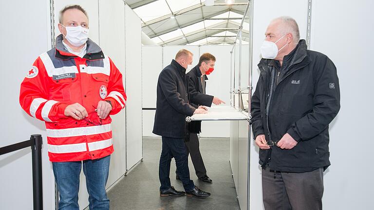 Landrat Thomas Ebert (Mitte links) und Würzburgs Oberbürgermeister Christian Schuchardt (Mitte rechts) bei einer gestellten Anmeldung im Impfzentrum auf der Talavera.