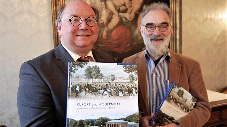 Die Herausgeber Peter Weidisch (links), Kulturreferent der Stadt Bad Kissingen, und Fred Kaspar, Mitarbeiter der LWL-Denkmalpflege, Landschafts- und Baukultur in Westfalen, präsentieren den Tagungsband 'Kurort und Modernität'. S Foto: Sigismund von Dobschütz       -  Die Herausgeber Peter Weidisch (links), Kulturreferent der Stadt Bad Kissingen, und Fred Kaspar, Mitarbeiter der LWL-Denkmalpflege, Landschafts- und Baukultur in Westfalen, präsentieren den Tagungsband 'Kurort und Modernität'. S Foto: Sigismund von Dobschütz