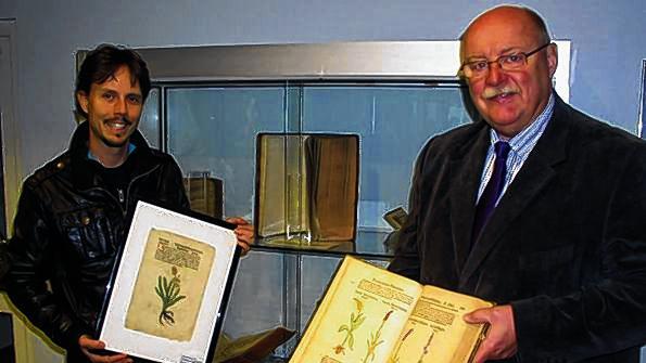 Bei der Ausstellungseröffnung präsentiert Mirko Wölfling (links) das älteste Exponat, den Druck des &bdquo;Wiesenknöterich&ldquo; von 1485 zusammen mit Bürgermeister Emil Heinemann (rechts).
