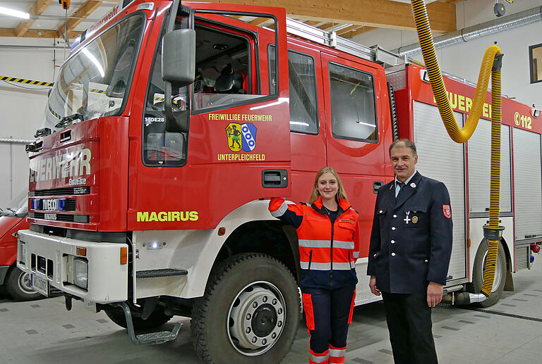 Laura Büttner und Oskar Schmitt im Unterpleichfelder Feuerwehrhaus mit dem aktuellen Tanklöschfahrzeug.