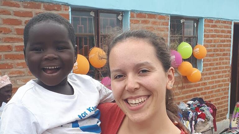 Kinderkrankenschwester Johanna Hofmann aus Bad Königshofen glücklich mit einem Waisenkind vor dem neuen Kinderheim.