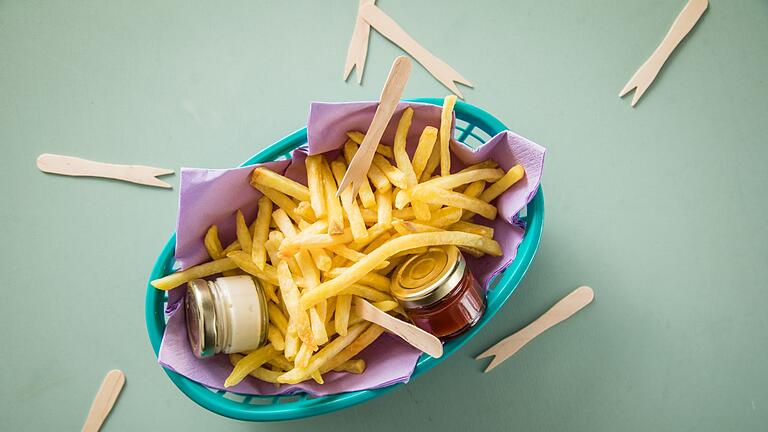 Pommes mit Mayo und Ketchup       -  Manchmal muss es eine Sünde sein: Pommes liegen bereit zum Dippen in Ketchup und Mayo.