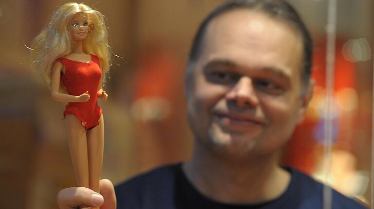 Kurator Roland Halbritter mit einer Barbie-Puppe im Museum Obere Saline.