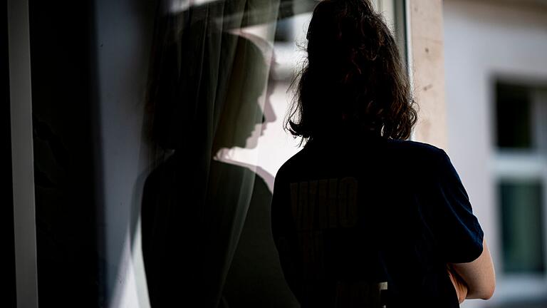 Frau schaut besorgt aus dem Fenster - Gerade junge Menschen fühlen sich durch Sorgen und Ängste wegen des Klimawandels belastet. Frau schaut besorgt aus dem Fenster - Gerade junge Menschen fühlen sich durch Sorgen und Ängste wegen des Klimawandels belastet.