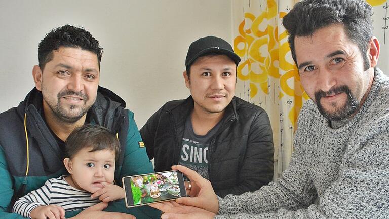 Hedayatullah Muslih, Muhammad Wafa und Sayed Eshag zeigen auf dem Handy, wie ein Frühlingsfest an Neujahr in Afghanistan gefeiert wird. Die Familie hat Zuflucht in Bad Königshofen gefunden.