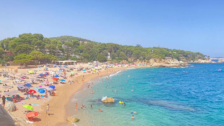 Spaniens Strände schrumpfen       -  Badegäste liegen in einer der vielen Buchten am Strand.