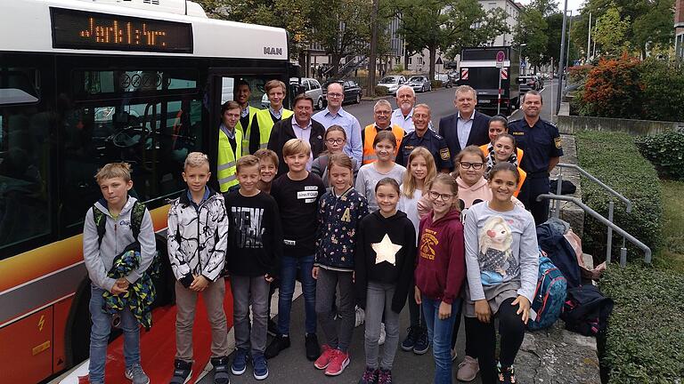 Verkehrssicherheitstag am Friedrich-Koenig Gymnasium in Würzburg. Im Bild-Vordergrund einige Schüler der Klasse 5b mit links Ulrich Fröhlich (WVV), StR Thomas Schmitt (Sicherheitsbeauftragter des FKG), Rainer Erhard (WSB), Clemens Großkopf-Klopf (Bundespolizei), Rainer Hellmann (Verkehrserzieher der Polizei), StD Markus Erdinger (Stellvertretender Schulleiter des FKG) und Volker Amon (Verkehrserzieher der Polizei). Links hinten: Auszubildende der WSB.