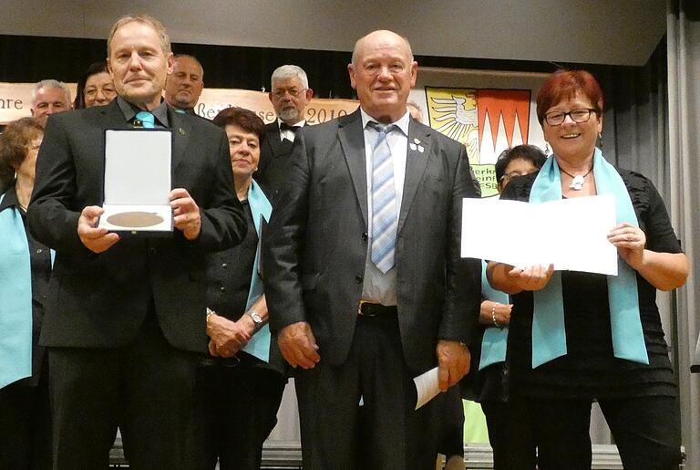 Verleihung der Zelterplakette durch Paul Kolb an den Vorsitzenden des Gesangvereins Eußenhausen, Reiner Zehe, und seine Stellvertreterin Gisela Beck, die durch den Jubiläumsabend führte. Verleihung der Zelterplakette durch Paul Kolb an den Vorsitzenden des Gesangvereins Eußenhausen, Reiner Zehe, und seine Stellvertreterin Gisela Beck, die durch den Jubiläumsabend führte.