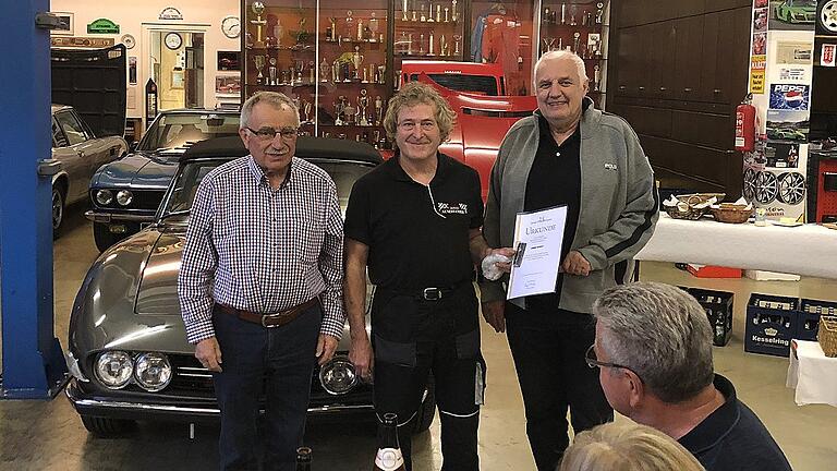 In der Oldtimerhalle von Ernst Plannasch (rechts) in Dettelbach ehrte AMC-Vorsitzender Walter Loschky (links) Armin Kunert für 25 Jahre Mitgliedschaft im ADAC.